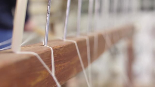 making traditional tapestry on a wooden weaving loom 