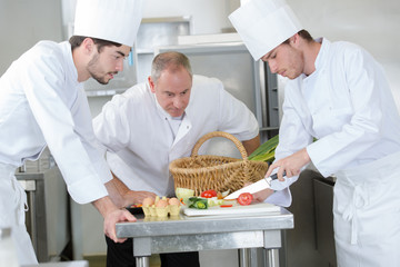 chef overseeing trainees prepping vegetables