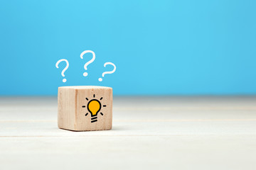 Concept of to find a creative idea or problem solving. Question mark and light bulb icons on wooden...