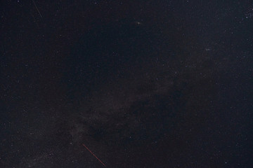 black night sky and stars as background, the milky way and falling Perseid meteors