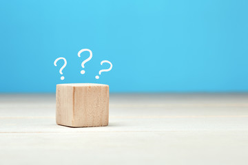 Wooden block with question marks. Uncertainty, confusion, surprise or faq concept.