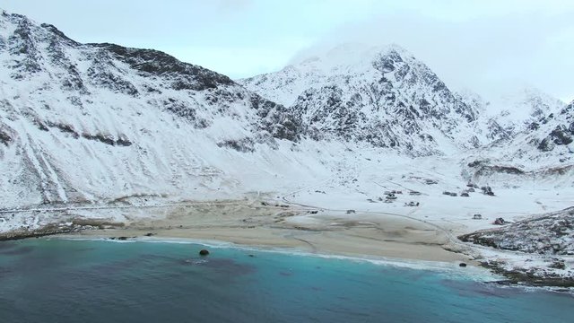 lofoten  snow capped haukland beach aerial view drone flying orbit over sea winter time