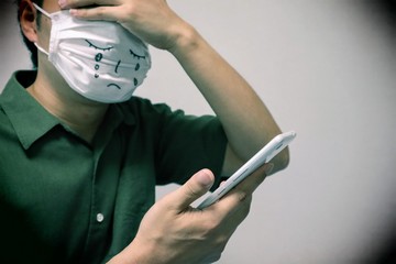 スマホを見て悲しむ男性のクローズアップ