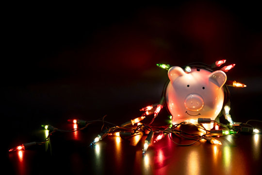 White piggy bank with Christmas string lights on happy December festival, Enjoy savings for spending money on the holiday's concept