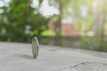 coins always have 2 side idiom idea concept, a Thai coin rolling on table with blurred background...