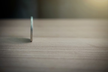 coins always have 2 side idiom idea concept, a Thai coin rolling on table with blurred background...