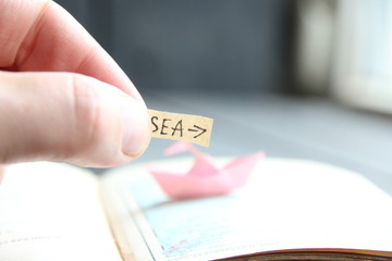 Pointer to the sea. Hand holds a pointer with the inscription.