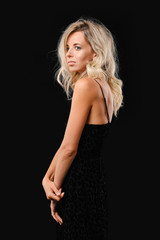 Fototapeta premium Low key photo of charming young woman with curly hair and black dress