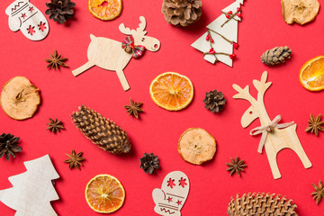 Top view of red background decorated with festive toys and Christmas symbols reindeers and New Year trees. Holiday concept