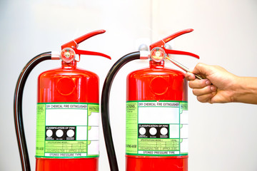Fire fighter are checking pressure gauge of red fire extinguishers tank in the building concepts of fire prevention emergency and safety rescue of fire services and training.