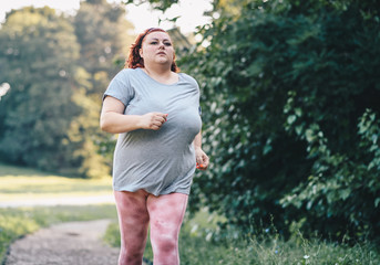 Image of a obese woman running in nature on a treadmill, doing weight loss training