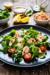 Salmon salad - roasted salmon and vegetables on wooden background
