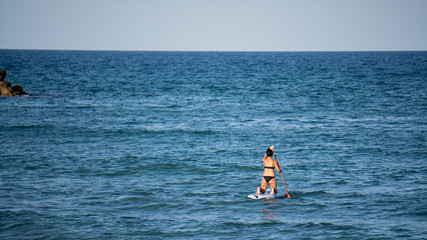 Mujer surfeando en el océano en un día soleado