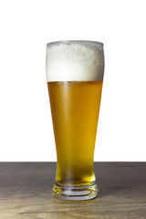 Full glass of beer, on a wooden table. Amber beer in a glass.