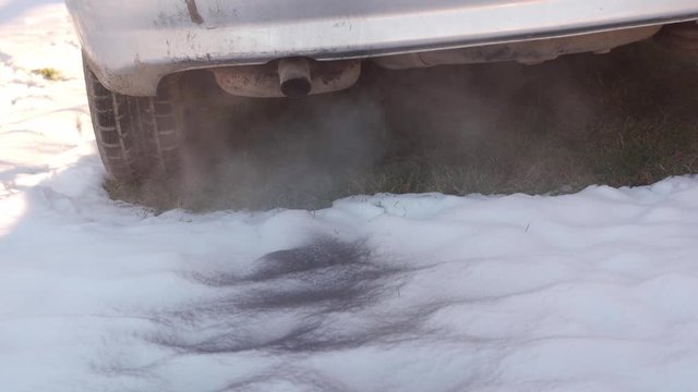 Diesel car start engine with big amount of smoke. Leaving black sign on the snow. Ecology problem with cars