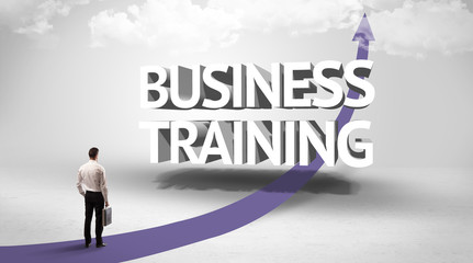 Rear view of a businessman standing in front of BUSINESS TRAINING inscription, successful business concept