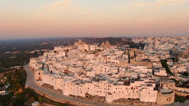 aerial view of ostuni old town drone flying orbit at sunset apulia italy
