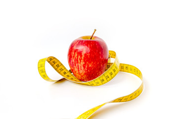 Red Apple with yellow measuring tape isolated on a white background. Healthy eating and calorie control concept.