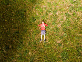 homme se reposant allong&eacute; dans l'herbe.  Gens couch&eacute; dans l'herbe. vue a&eacute;rienne d'un homme allong&eacute; dans l'herbe