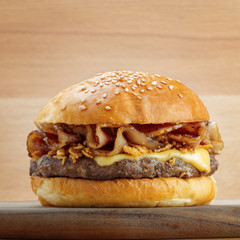 Fresh burger with cheese on wooden background