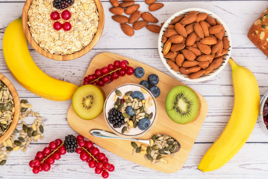 Fruits and Breakfast with Whole grains and nuts, yogurt mix with Cherry , banana, avocado in the wooden table. Breakfast for Health and Diet concept