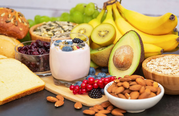 Fruits and Breakfast with Whole grains and nuts, yogurt mix with Cherry , banana, avocado in the wooden table. Breakfast for Health and Diet concept