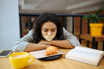 Pretty female student with her mouth taped shut