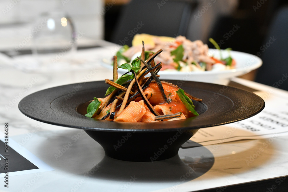 Sticker closeup shot of delicious dish made with seafood and seasonings in a black plate