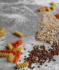 Top view of fusilli pasta and grains: buckwheat, oats, quinoa. Image with copy space for text. Food background.