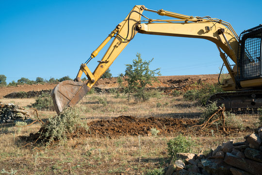 Crawler Excavator Working At The Construction Site. Construction Machinery For Excavating, Loading, Lifting And Hauling Of Cargo On Job Sites