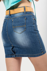 girl in a denim short skirt close up on a white background