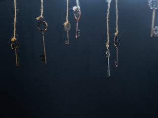 Fototapeta na wymiar A lot of different old keys from different locks, hanging from the top on strings.