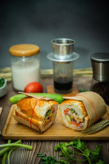Snack at break time. Famous Vietnamese food is Banh mi thit and black coffee, popular street food from bread stuffed with raw material: pork, ham, pate, egg and fresh herbs.Typical Vietnamese sandwich