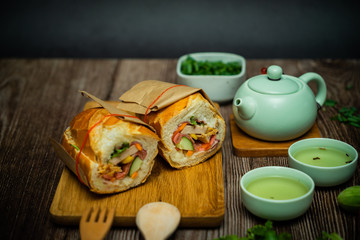 Famous Vietnamese food is Banh mi thit and hot tea, popular street food from bread stuffed with raw material: pork, ham, pate, egg and fresh herbs.Typical Vietnamese sandwich