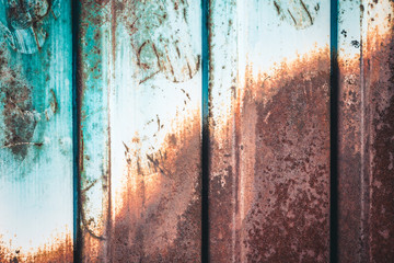 Rusty metal fence of corrugated flooring. Rear background.