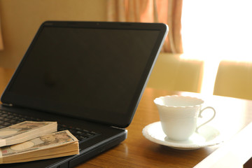 テーブルの上のパソコンと現金