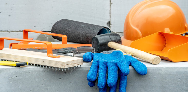 Set of construction tools on the background of a wall of aerated concrete blocks on a building site