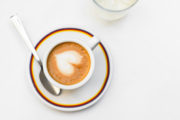 Cappuccino coffe cup with latte art heart. on a gray background. top view copy space