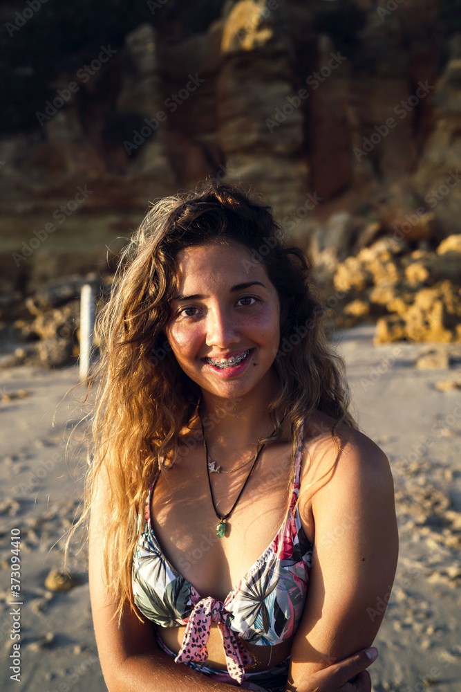 Sticker vertical portrait of a female in swimsuit on background of a cliff