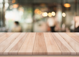 Empty wooden table with blurred cafe and coffee shop interior background