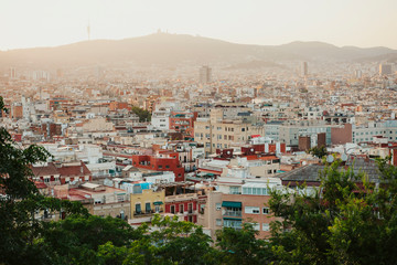 Fototapeta premium Sunset in city surrounded by mountains in Barcelona.