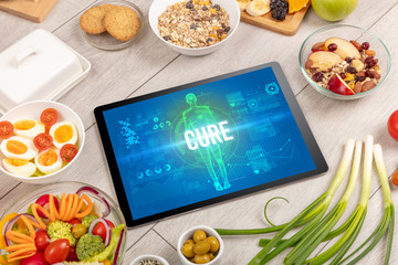 CURE concept in tablet with fruits, top view