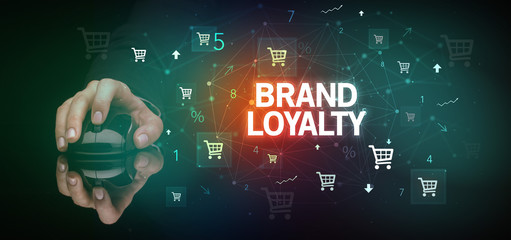 hand holding wireless peripheral with BRAND LOYALTY inscription, online shopping concept