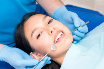 Naklejka premium dentist examines the patients teeth at the dentist.