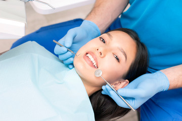 Fototapeta premium Attractive young woman in a dental clinic with a male dentist. Healthy teeth concept.