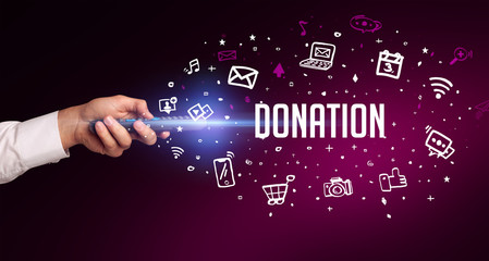 hand holding wireless peripheral with DONATION inscription, social media concept