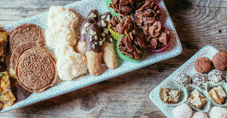 Traditional homemade Christmas cookies: Variety of sweet European cookies on rustic wooden desk, powdered sugar.