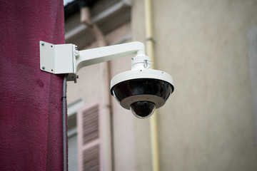 Closeup of security camera on stoned wal in the street