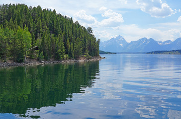 Fototapeta premium View of mountain peaks reflecting in water in summer in Grand Teton National Park in Wyoming, United States
