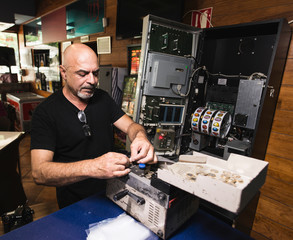Mature man raises money from a slot machine